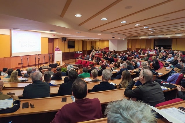 Iso auditorio täynnä yleisöä, kuvattu takarivistä kohti esityslavaa.