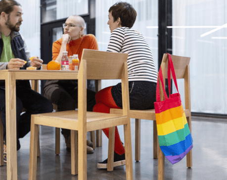 Kolme eri-ikäistä henkilöä istumassa pöydän äärellä.