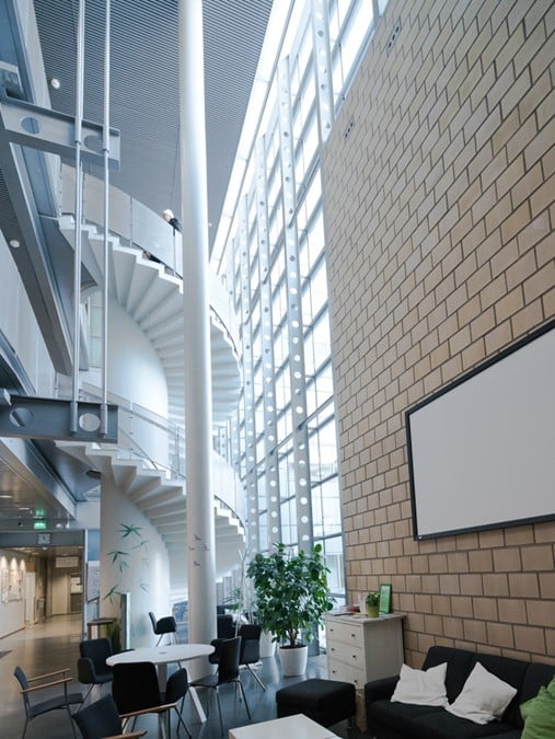 Myyrmäen kampuksen sisätila, valkoiset kierreportaat ja kermanväristä tiiliseinää