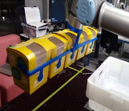 Tarttuja poimii rivin silmusalaatti laatikoita.