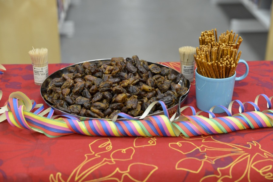 Taateleita laakeassa hopeanvärisessä astiassa joka on punaisen pöytäliinan päällä