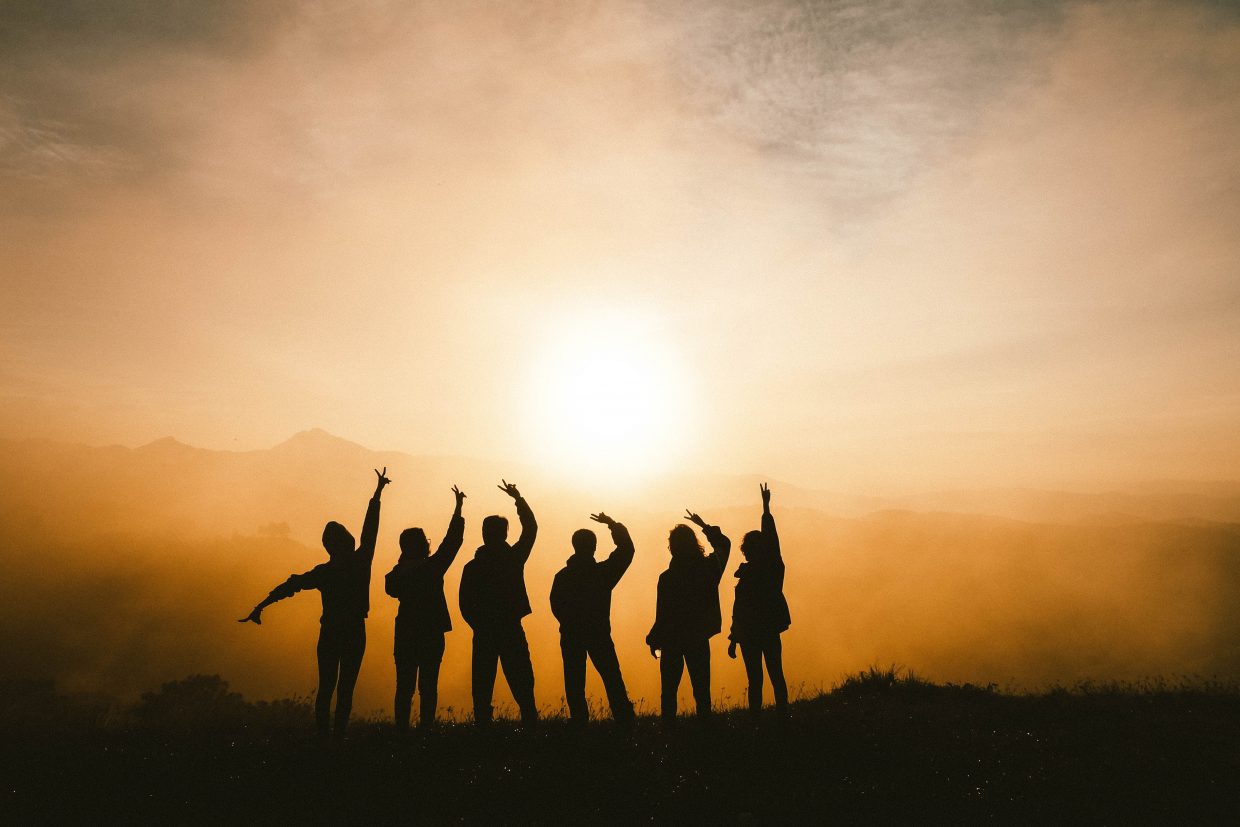 siluettikuva kuusi ihmistä seisoo rivissä taustalla aurinko