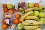 hivenen ylikypsiä hedelmiä, banaaneja, omenoita ja sitrushedelmiä valkoisella alustalla