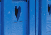 Sinisiin puuoviin leikattu sydämenmuotoinen aukko