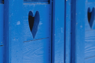 Sinisiin puuoviin leikattu sydämenmuotoinen aukko