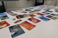 Värikkäitä kuvakortteja levitettynä pöydälle työpajassa.