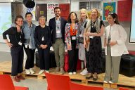 Ryhmäkuvassa kahdeksan ihmistä rinnakkain, hymyilevät, NEB Stewardship Lab -koordinaattoritiimin jäseniä ensimmäisessä kasvokkaintapaamisessa Lissabonissa maaliskuussa 2023.