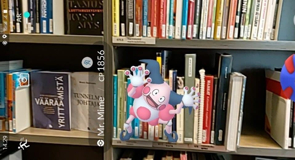 http://Kirjaston%20kirjahyllyjen%20edessä%20Pokemon-hahmo