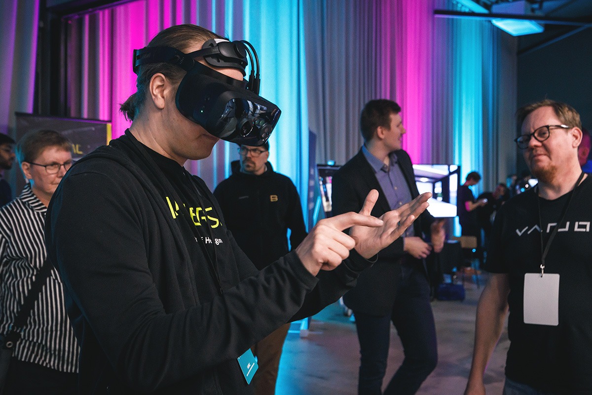 Henkilöllä on XR-lasit päässä, ja hän katsoo niillä kohti kohotettuja käsiään. Hän osoittaa toisella kädellään kämmentään.