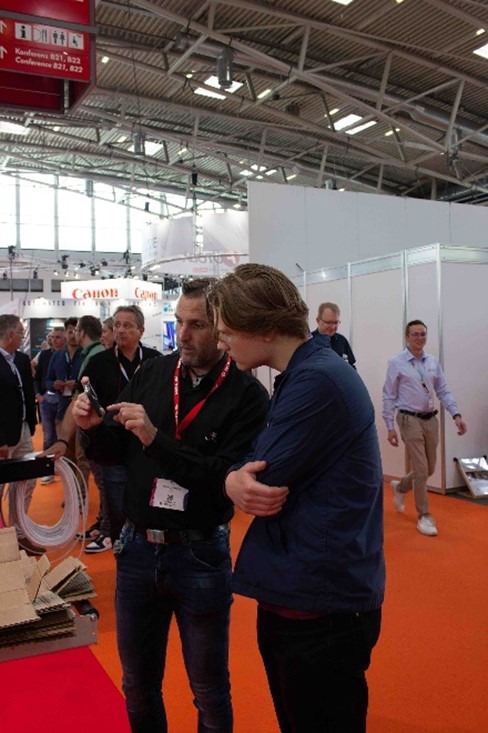 Kuvassa valmistajan edustaja kertoo tulostustekniikan erikoisuuksista opiskelijalle