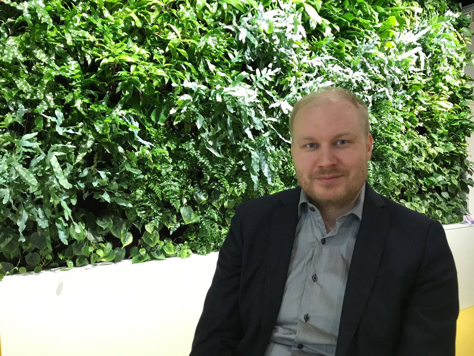 Joonas Pusila, puolikuva, taustalla vihreä pensas